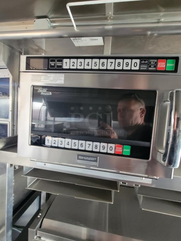 Sharp commercial microwave with digital keypad, stainless steel, model Twin Touch indicated. Appears in good condition.