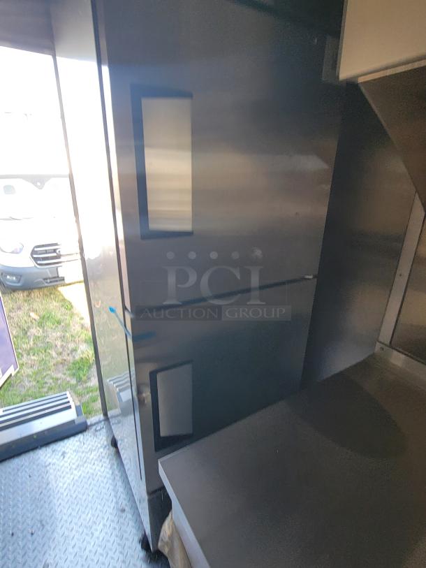 Industrial stainless steel refrigerator with two visible compartments, in excellent condition, featuring a metal interior and exterior.