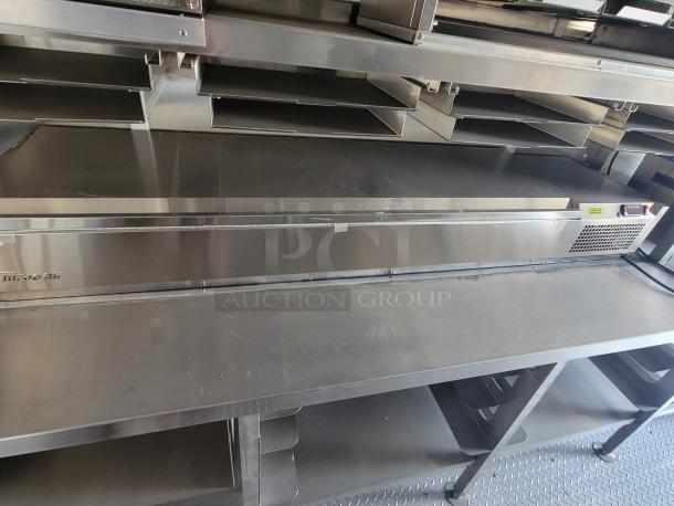 Stainless steel commercial kitchen equipment with multiple shelves, labeled "Turbo Air" on one side, appears in good condition.