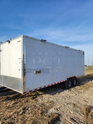 White Rock Solid enclosed trailer, dual axle, metal trim, power outlets, reflective strips, outdoor setting, good condition.