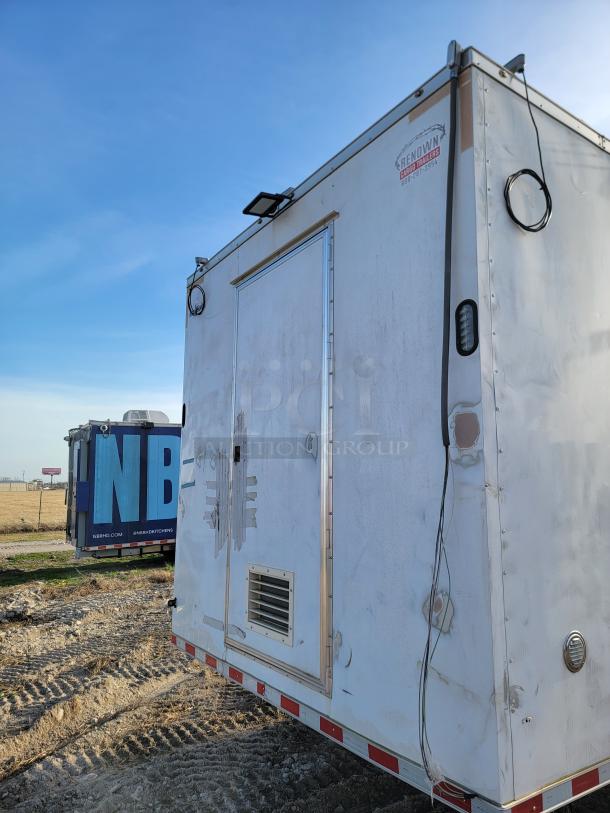 White Renown Cargo Trailers unit with visible wear, side vent, and exterior light fixtures. Branding label on top right corner.