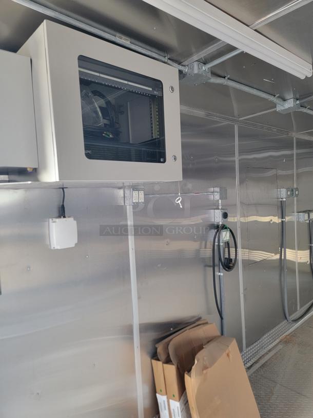 Interior of a metal storage container with visible electrical panel and wiring. Boxes stacked on the floor. Good condition.