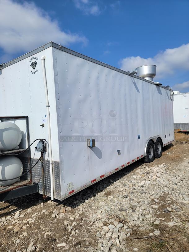 White Diamond Cargo trailer, dual axles, roof vent, gas tanks attached. Clean exterior, suitable for mobile business.