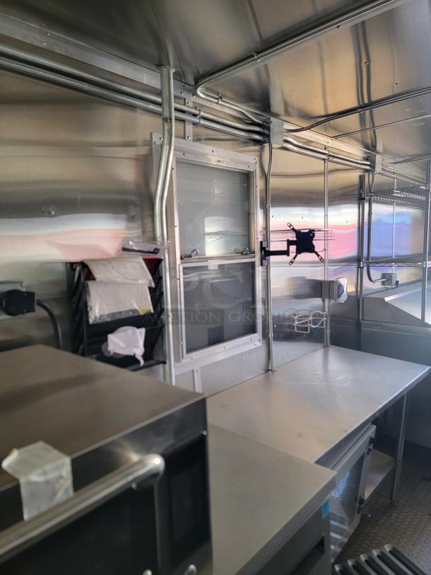 Mobile kitchen interior, stainless steel surfaces, shelving, and equipment slots. Clean condition, ready for customization.