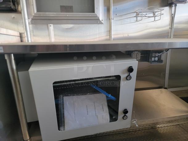 Secure white metal cabinet under silver countertop, featuring two locking knobs. Contains documents and cables inside.