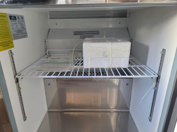 Interior of a medical refrigerator with a foam box on wire shelf, warning labels visible; clean condition, model AC12ET.