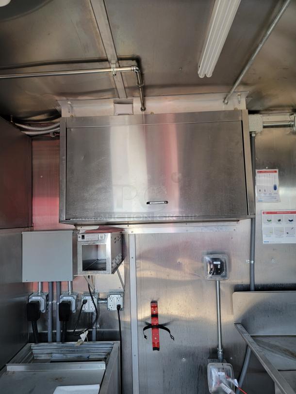 Commercial kitchen interior with stainless steel cabinetry, electrical outlets, and control panels. Appears in good condition.