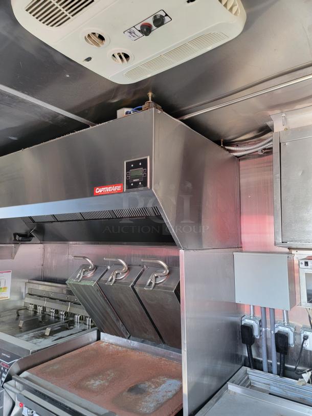 Commercial kitchen ventilation hood, CaptiveAire brand, stainless steel, integrated with exhaust fan system, used condition.