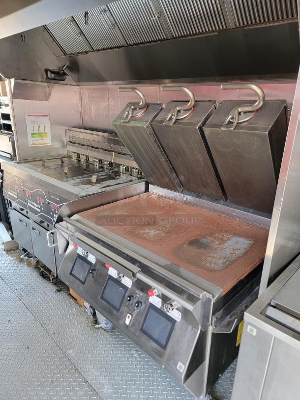 Commercial kitchen griddle with three hinged lids, digital controls, stainless steel finish, slight surface rust.