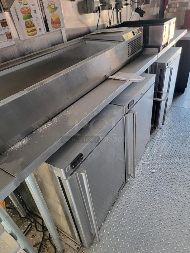 Stainless steel commercial refrigerator units, multiple compartments, minor wear, digital controls, ideal for food service setups.