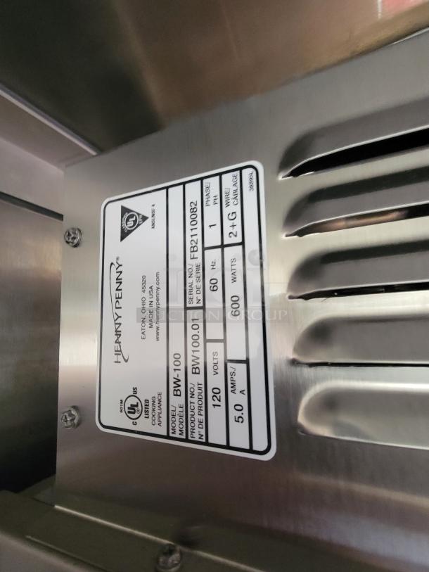 Henny Penny cooking appliance model BW-100, serial FB2110082. Label shows 120 volts, 600 watts, 5.0 amps.