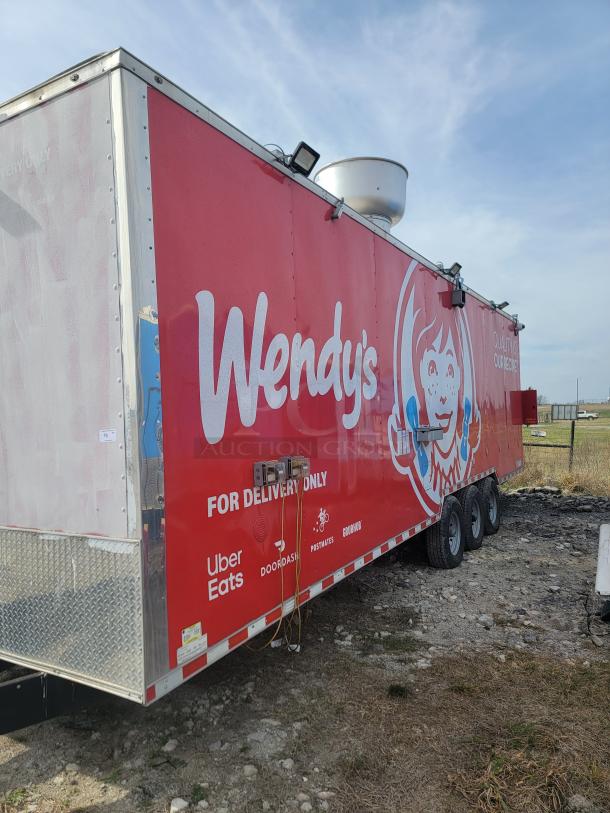 Wendy's branded food truck with delivery service logos, in used condition, parked on gravel.