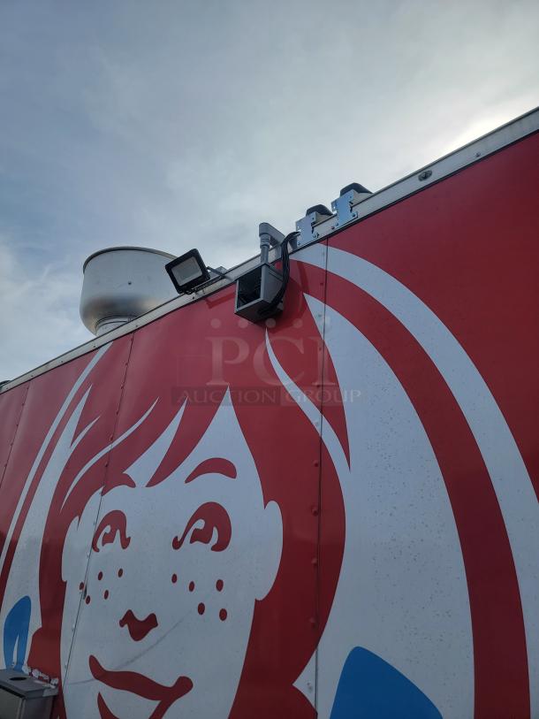 Red food truck with graphic design. Features rooftop exhaust and lighting. Condition appears good; no tags or labels visible.