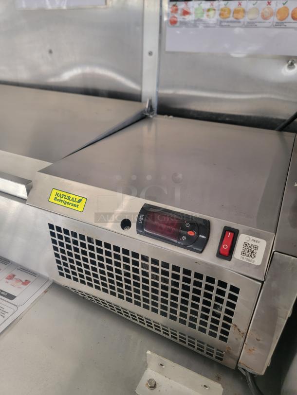 Commercial stainless steel refrigeration unit with digital controls. Features "Natural Refrigerant" label and QR code. Appears in used condition.