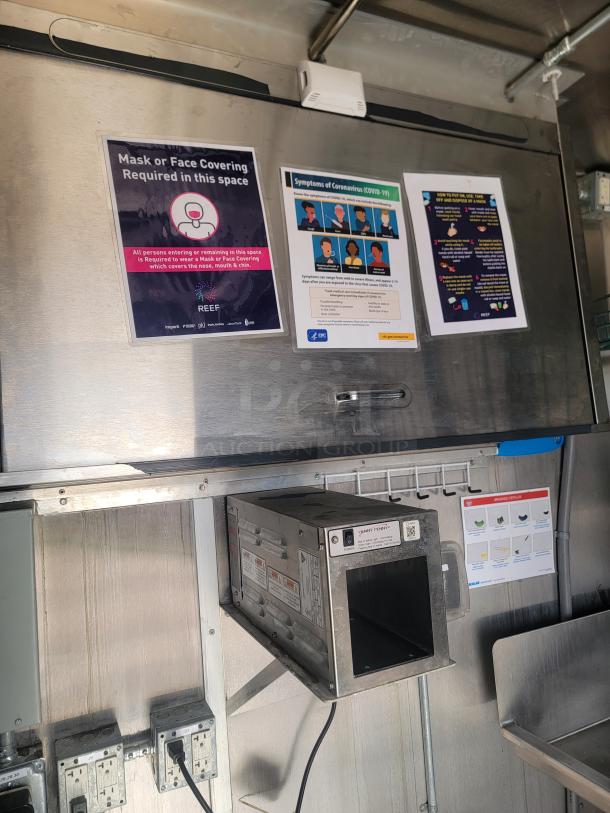 Industrial food truck interior showing metal surfaces with a mounted JetAir Technologies Jet-1-HP hand dryer. COVID-19 safety posters on the wall.