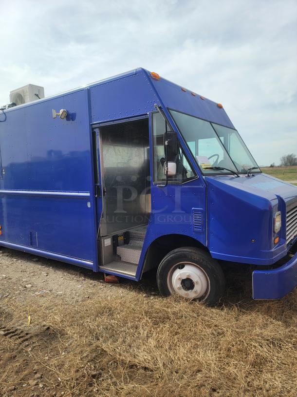 Blue food truck with side serving window, showing moderate wear. Features an A/C unit on top. Suitable for customization.