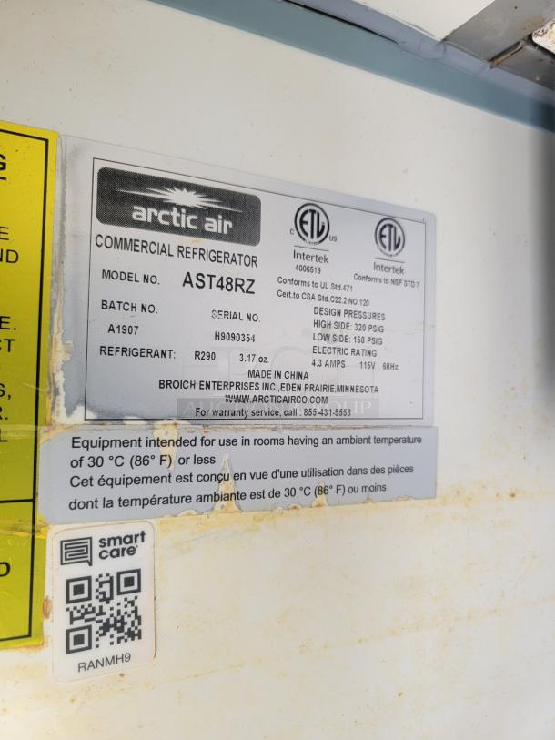 Arctic Air AST48RZ commercial refrigerator label, model info, design pressures, refrigerant type, and contact details visible.