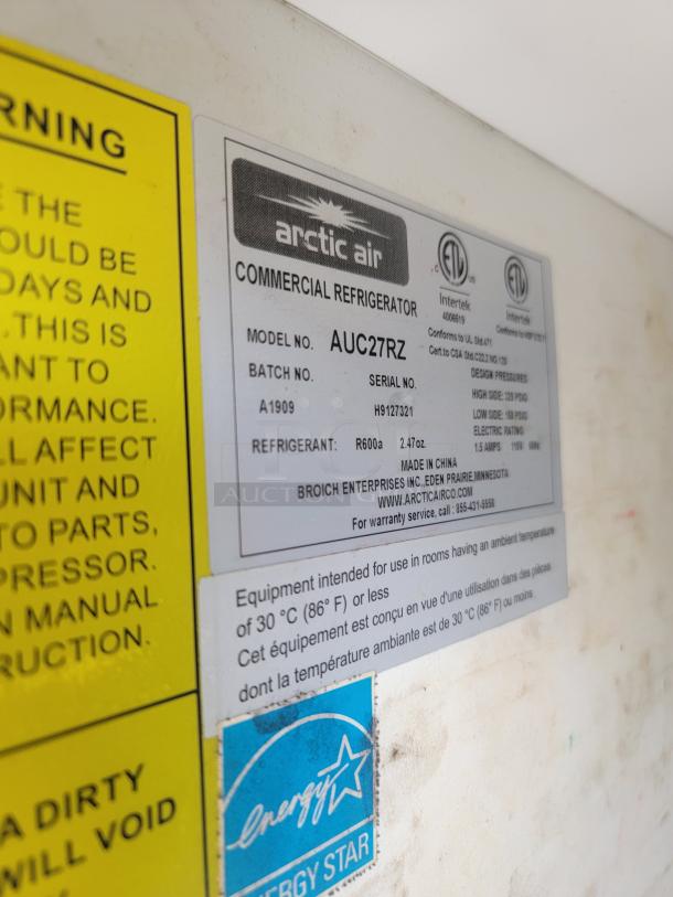 Arctic Air commercial refrigerator model AUC27RZ, shows label with serial H9127321, uses R600a refrigerant, Energy Star rated.