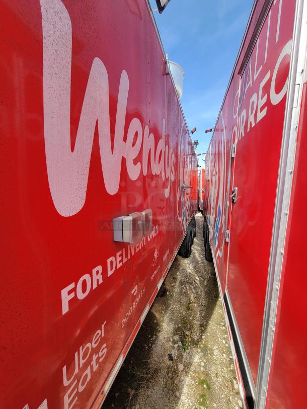Bright red Wendy's delivery truck side, featuring logos for Uber Eats, DoorDash, and Postmates. Clean and well-maintained condition.