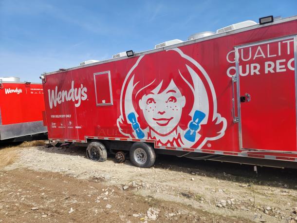 Red Wendy's food truck with logo, labeled "For Delivery Only," featuring Uber Eats, Doordash, and Grubhub logos. Two flat tires.