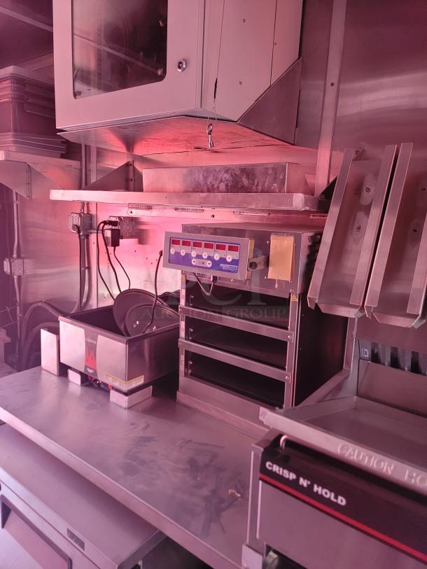 Commercial kitchen equipment featuring a Crisp N' Hold unit, open shelving, and control panel; stainless steel condition.