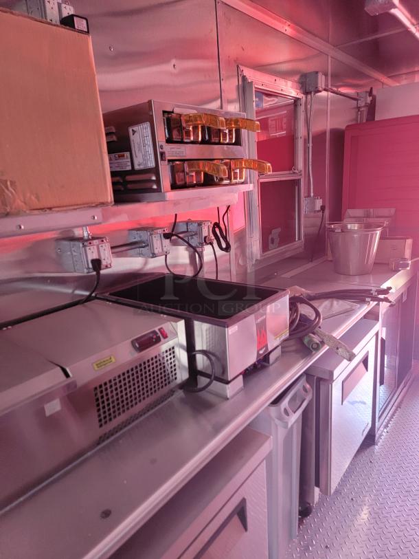 Commercial kitchen equipment in a stainless steel setup, featuring fryers, cooling units, and electrical wiring, in good condition.