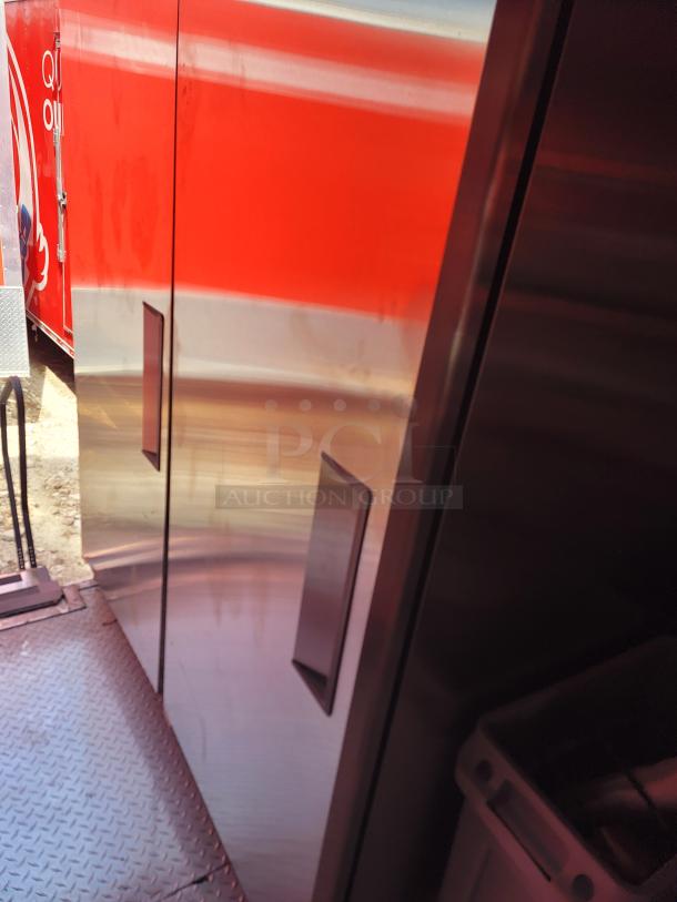 Interior view of a red food truck with stainless steel finish and diamond plate flooring, in good condition.