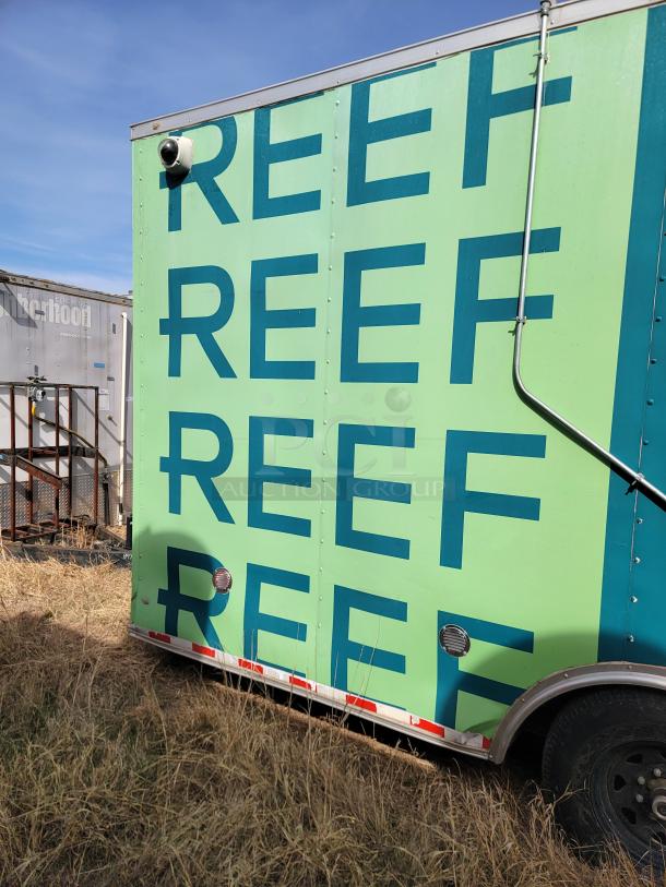 Green food truck with "REEF" text, equipped with security camera, outdoor setting, side view. Good condition.