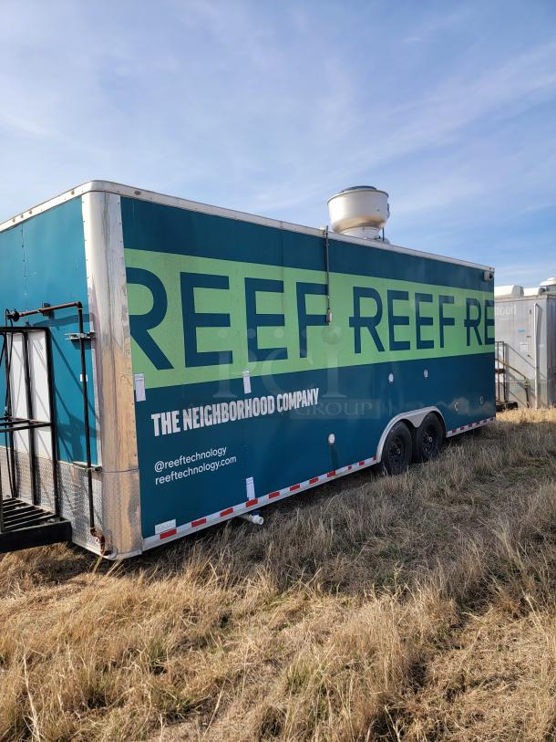 Mobile kitchen trailer by Reef Technology, blue with branding. Used condition, dual axles, side vent. Marked "The Neighborhood Company."