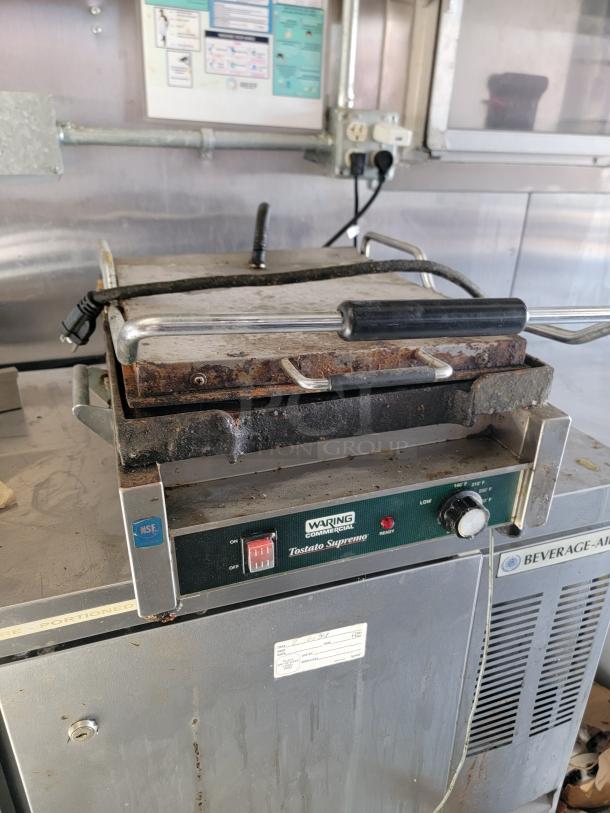 Waring Commercial Tostato Supremo panini press in used condition, showing signs of wear, with visible control panel.