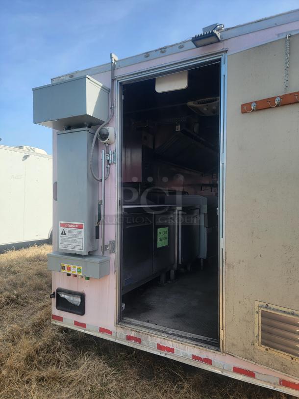 Mobile kitchen trailer with open door revealing stainless steel counters and equipment. External panel labeled "Danger." Good condition.