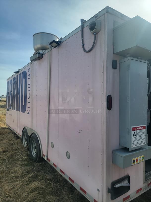 Mobile kitchen trailer by Hybrid Kitchens, pink exterior, dual axles, roof ventilation, mounted security camera, in used condition.