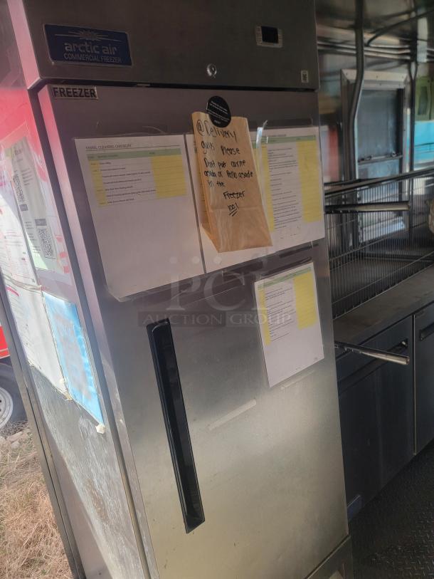 Arctic Air commercial freezer, stainless steel, good condition, labeled "FREEZER," with visible notes on the front.