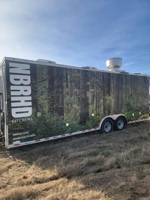NBRHD Kitchens food trailer; forest mural, dual-axle, roof vent. Exterior in good condition. Branding visible: NBRHD, @NBRHDKITCHENS.