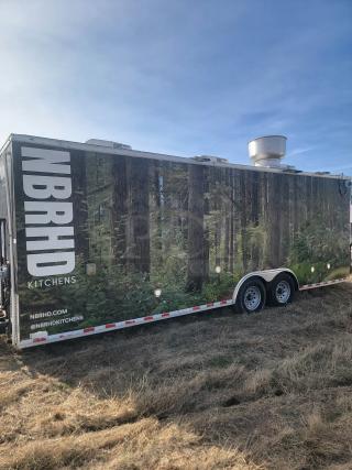 NBRHD Kitchens food trailer; forest mural, dual-axle, roof vent. Exterior in good condition. Branding visible: NBRHD, @NBRHDKITCHENS.