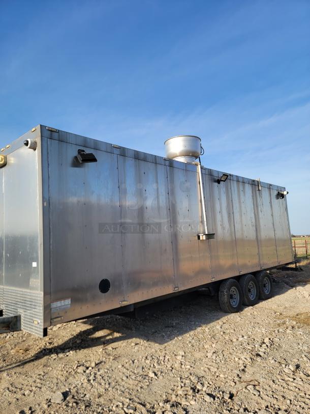 Large silver metal trailer with ventilation system on gravel. Triple-axle wheels, visible wear. Suitable for conversion or transport.