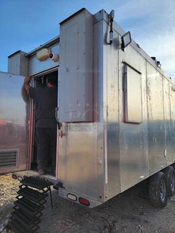 Mobile trailer unit with silver exterior, equipped with surveillance cameras and mounted lights. Shows signs of outdoor use.