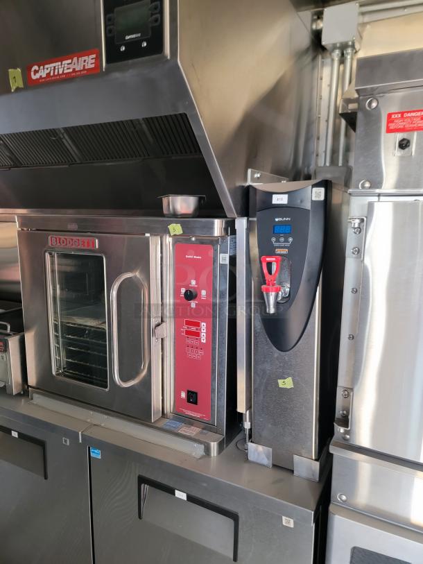 Commercial kitchen equipment set featuring a Blodgett oven with clear glass door, alongside a Bunn water dispenser. Both in stainless steel.