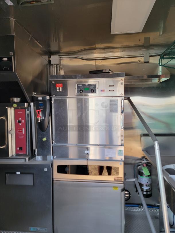 Stainless steel commercial oven with digital controls and visible label. Appears in excellent condition, mounted in a kitchen setting.