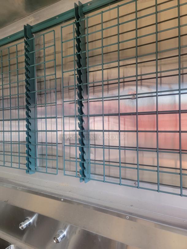 Stainless steel industrial grill with teal grid dividers, featuring adjustable knobs and metallic finish, in excellent condition.