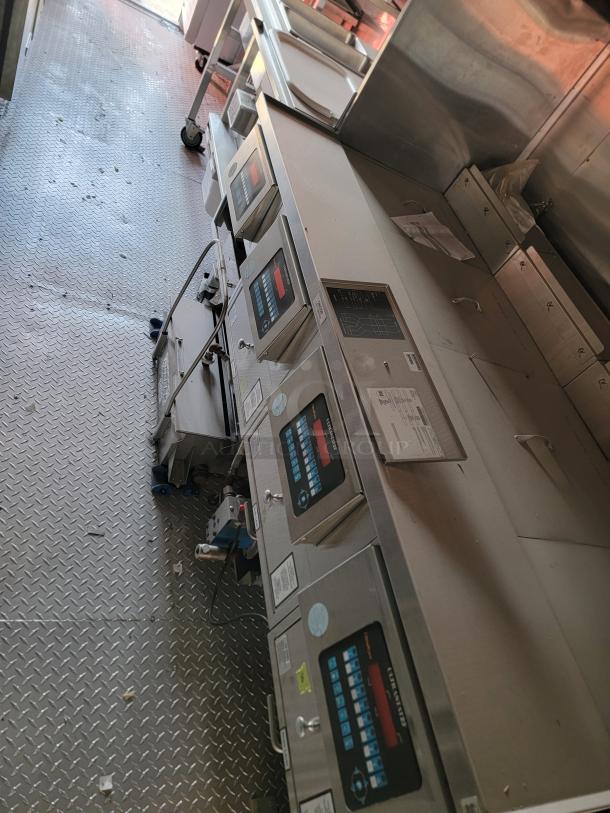 Commercial kitchen fry station with digital controls and stainless steel finish, featuring multiple sections. Appears in used condition.