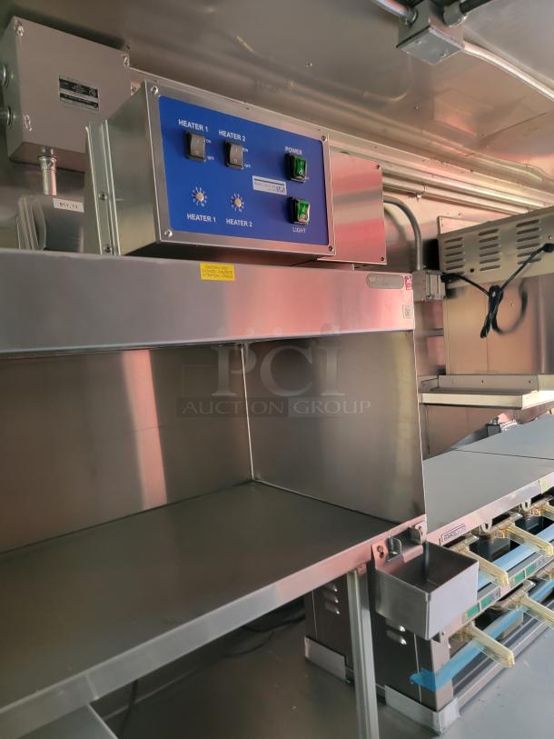 Stainless steel commercial warming station with dual heaters, control panel, and caution label visible, in excellent condition.