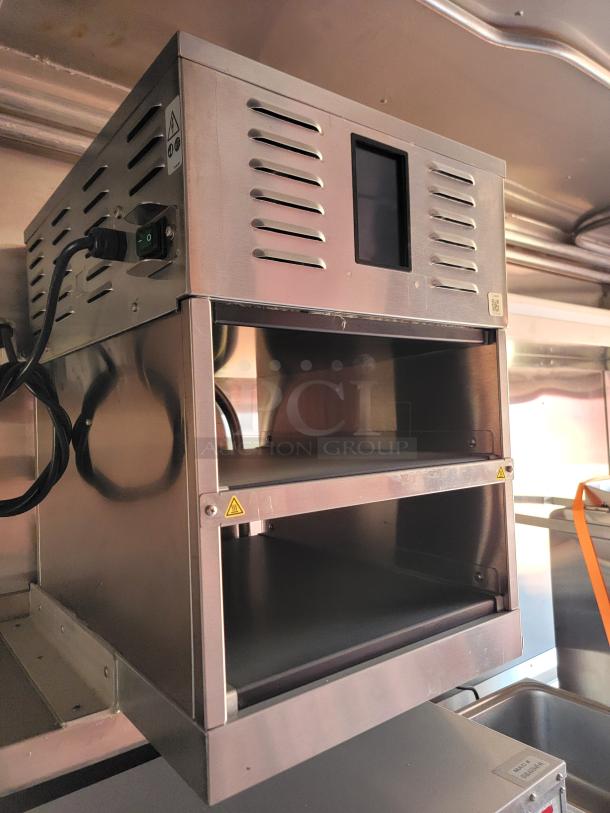 Stainless steel commercial food warmer with dual shelves, power switch, and caution labels. Appears in good condition.