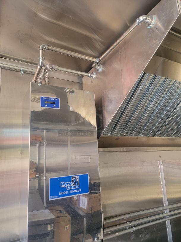 Stainless steel Pyro-Chem Model EN-MCU3 fire suppression system in excellent condition, visible system status label.