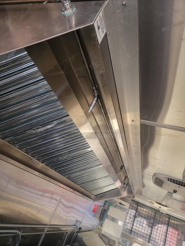 Commercial stainless steel ventilation hood, showing ducting and fittings. Appears in good condition with visible labels and hardware.