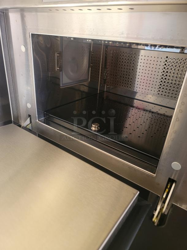 Stainless steel oven interior, featuring perforated panels and a sleek, reflective finish. Appears in excellent condition.