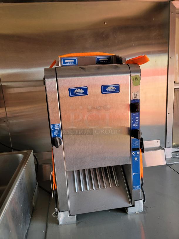 Stainless steel conveyor toaster with Crown labels, used condition, multiple toasting settings, located in a kitchen setting.