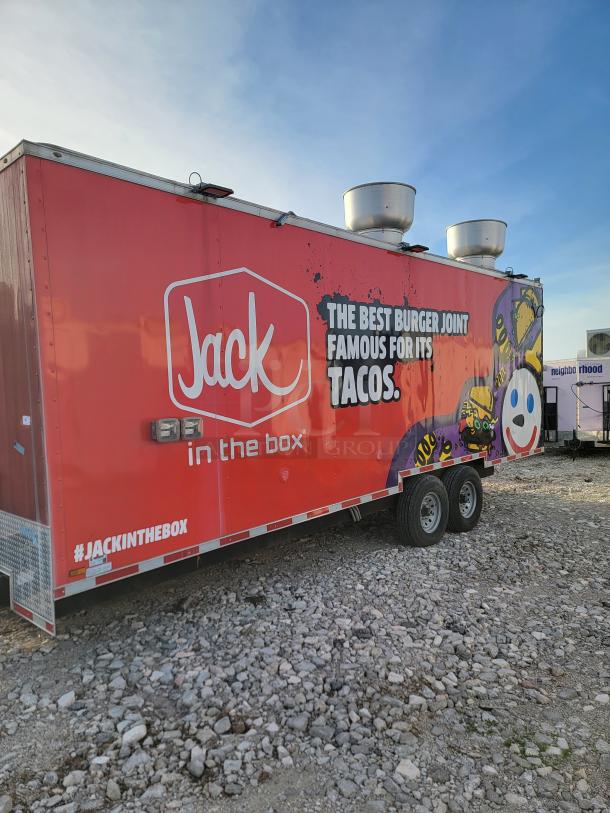 Red "Jack in the Box" food trailer with logo and taco slogan. Equipped with ventilation units. Slightly worn exterior.