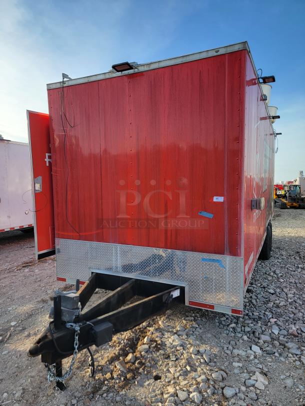 Red rectangular trailer with a black hitch, diamond plate trim, and exterior lights. Visible wear on the surface.