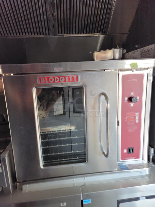 Blodgett commercial oven with glass door and control panel. Stainless steel exterior. Model and specs labeled. Good condition.